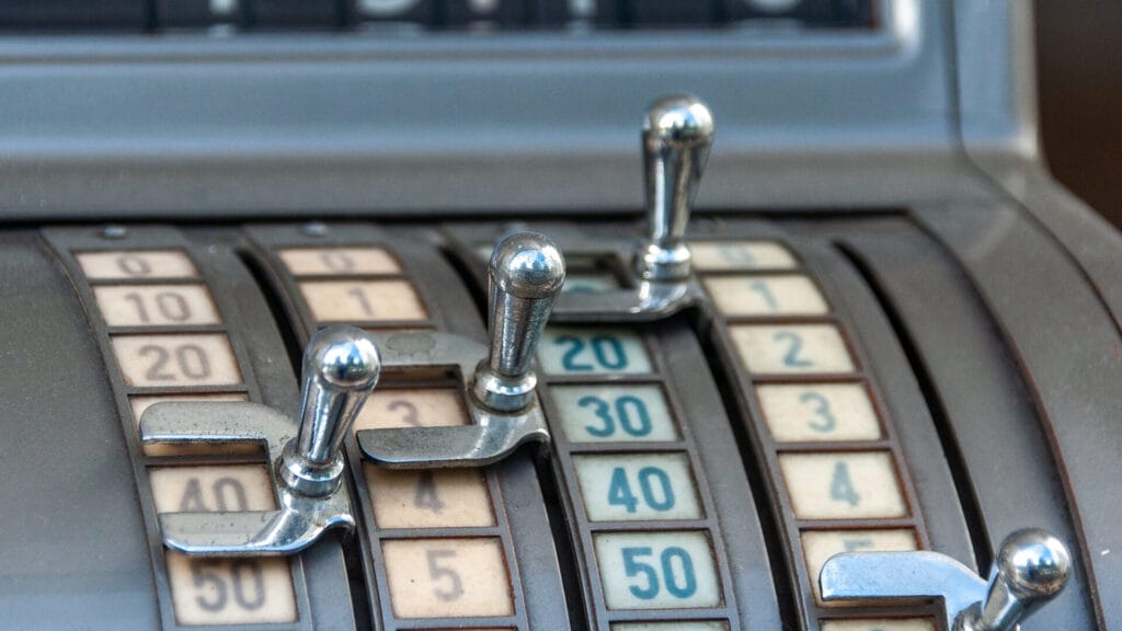 Alte Registrierkasse mit Hebeln und Zahlen Darstellung für strukturierte und präzise Kontierung in der Buchhaltung.